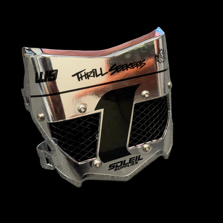 A metallic silver motocross face shield with black graphics, including a large number 1 and &