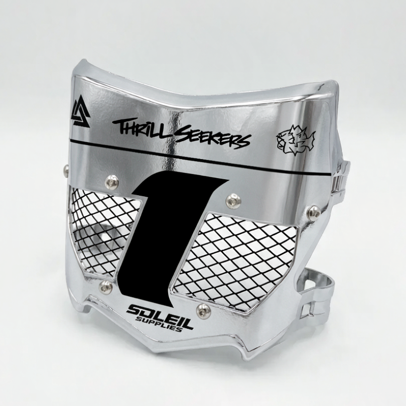 A silver metallic motocross face guard with black mesh grilles, a large black number 1 on the front, and printed branding including &