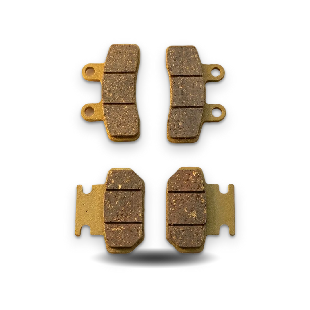 Four brake pads on a textured beige surface with &