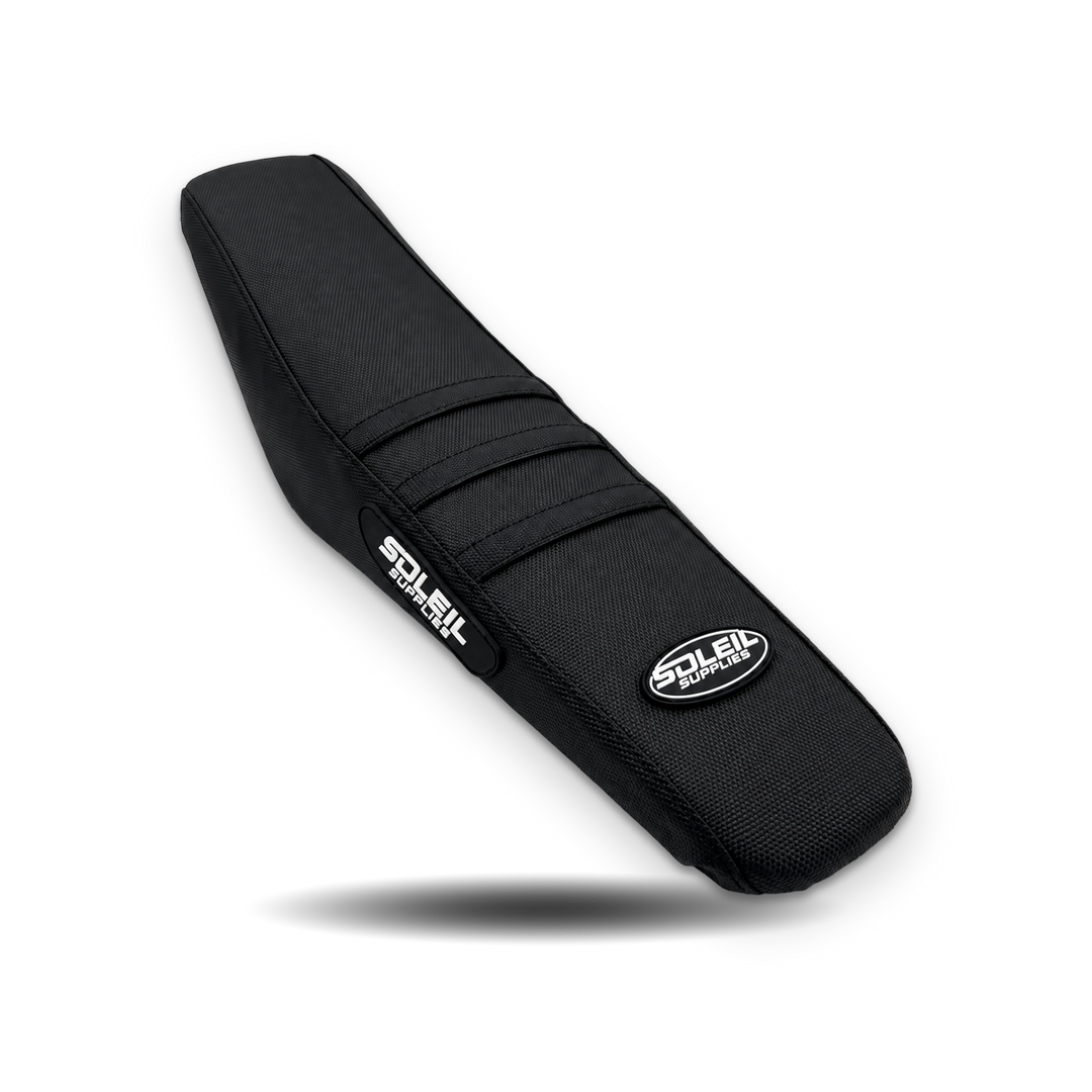 Black Yozma Soleil Supplies seat cover with white logos and four grip ribs on white
