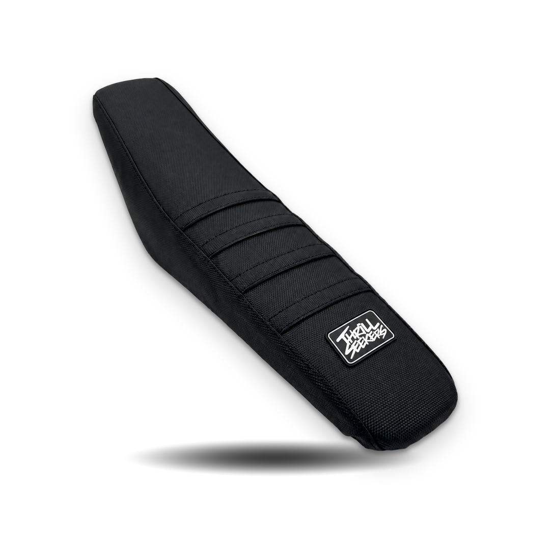 Black Yozma Thrill Seekers seat cover with white logo and four grip ribs on white