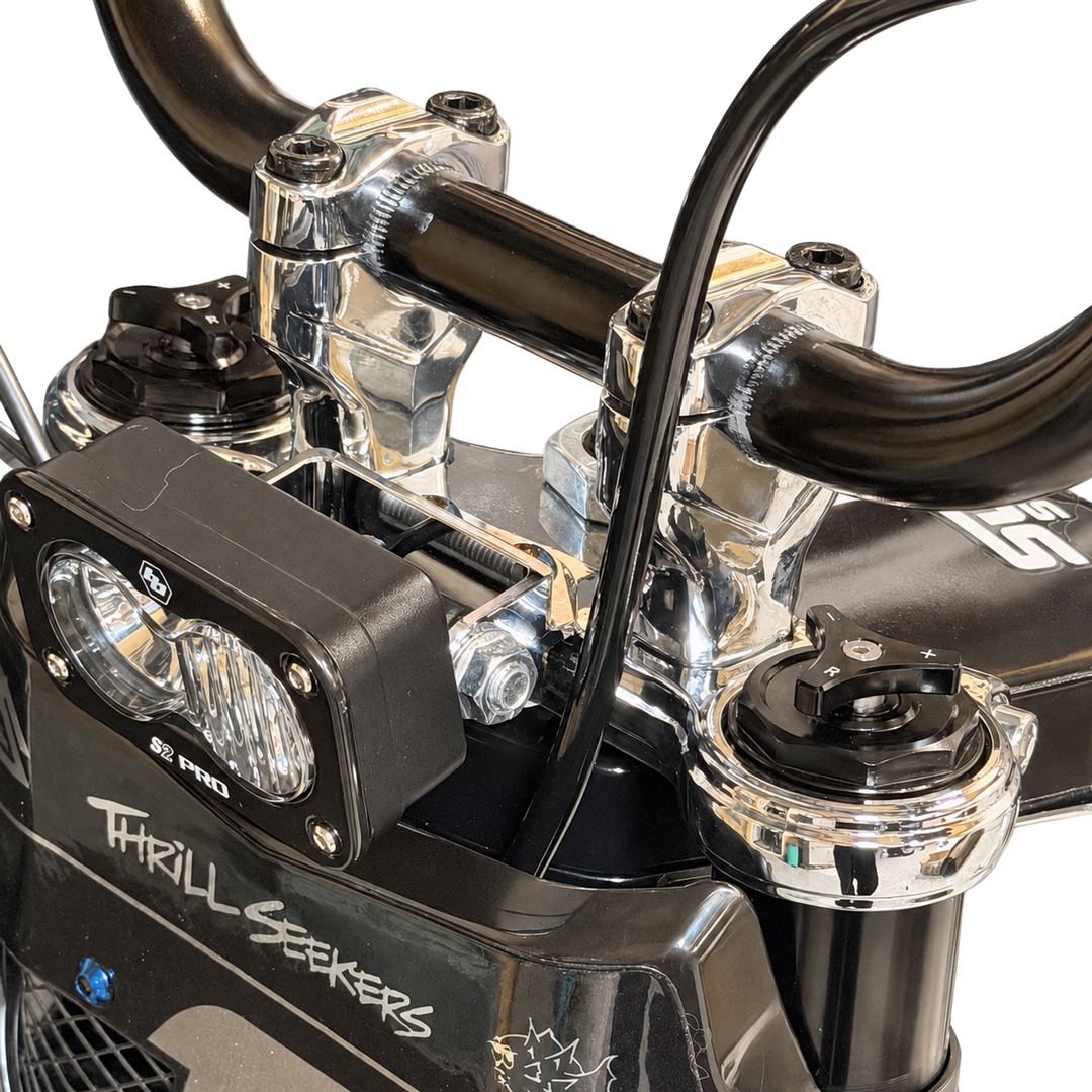 Close-up of Tuttio chrome triple clamps and handlebar risers installed on the bike
