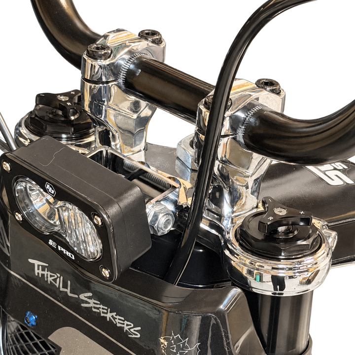 Close-up of Tuttio chrome triple clamps and handlebar risers installed on the bike