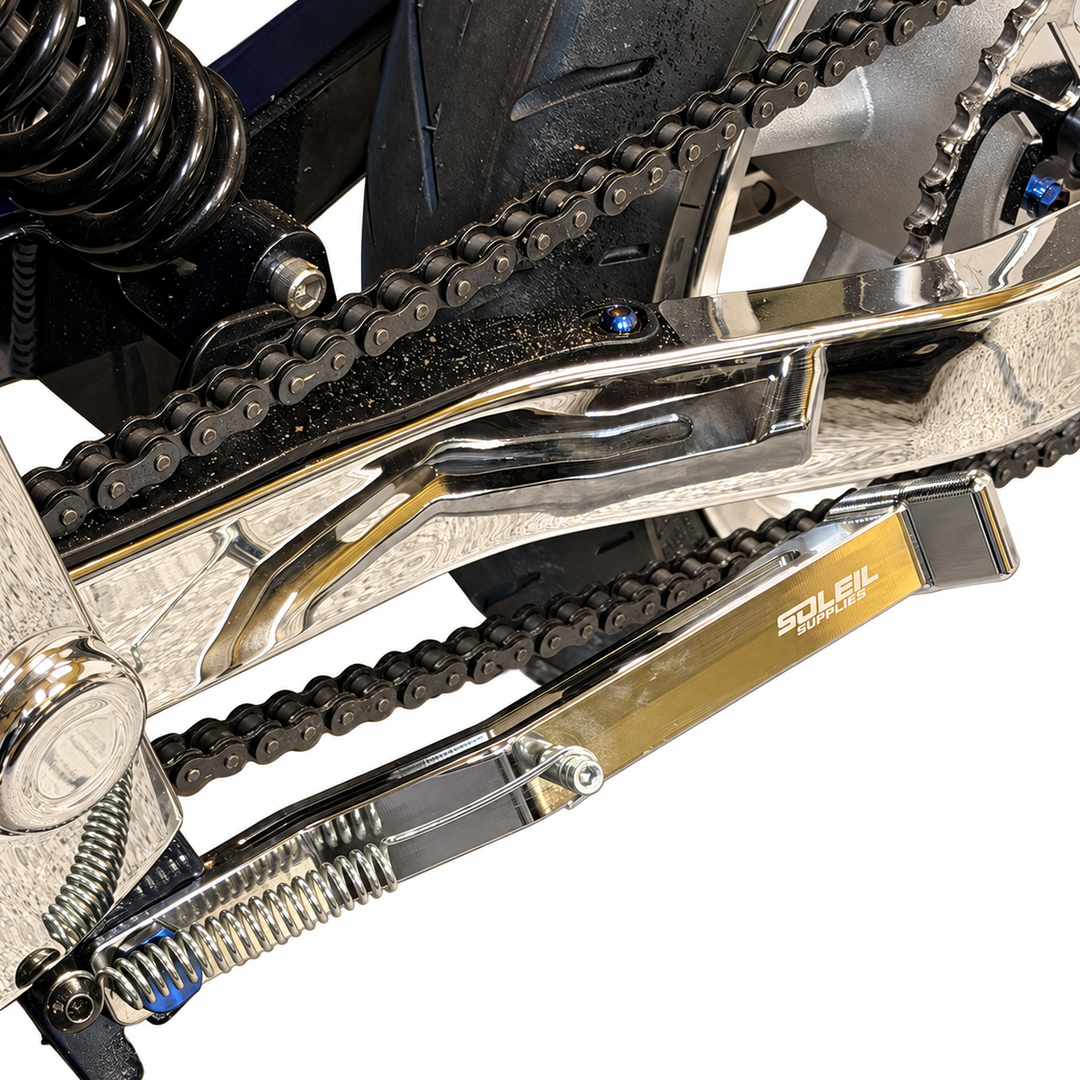 Tuttio upgraded kickstand folded alongside the bike swingarm, showing spring and mounting hardware