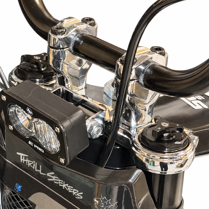 Close-up of Tuttio chrome triple clamps and handlebar risers installed on the bike